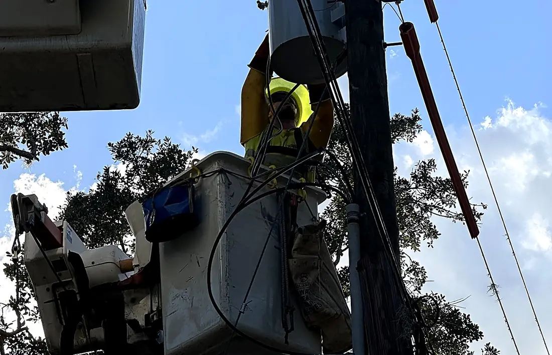 Lineman working from a bucket at a distribution pole